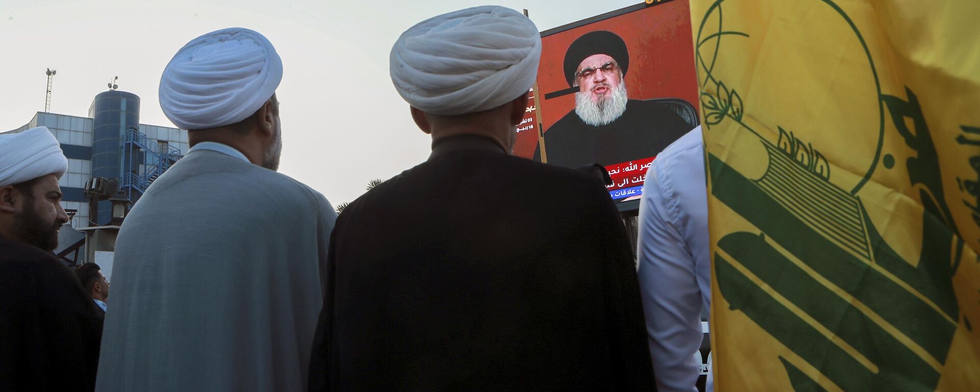 Iraqi demonstrators watch a speech from Lebanon's militant Hezbollah leader Sayyed Hassan Nasrallah on a screen as they hold flags of, Hezbollah during a pro-Palestinian rally in Basra, Iraq, Friday, Nov. 3, 2023.  - Sputnik International, 1920, 05.11.2023