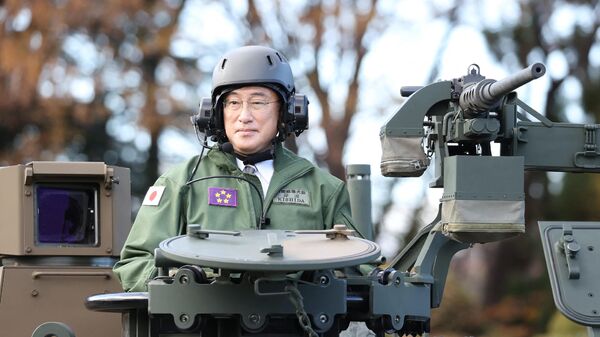 Japan's Prime Minister Fumio Kishida (L) rides on a Japan Ground Self-Defense Force (JGSDF) Type 10 tank during a review at JGSDF Camp Asaka in Tokyo on November 27, 2021. - Sputnik International