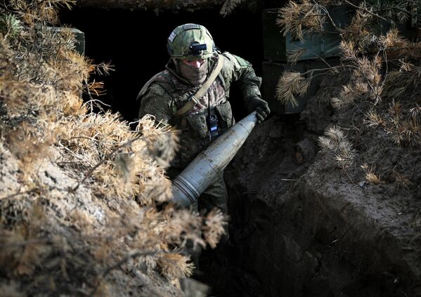 Trooper carries a Giantsint-B shell through a trench. Shells can weigh 45 kg or more, depending on variant. - Sputnik International