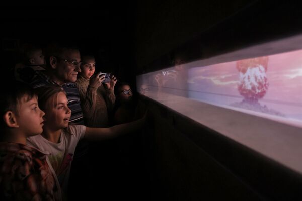 Visitors watch a video of a nuclear bomb test. - Sputnik International