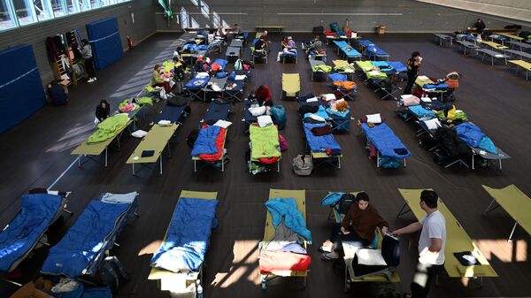Ukrainian refugees are accommodated in a sports hall equipped with camp beds in the small Bavarian village of Eichenau near Munich, southern Germany, on March 24, 2022. - Sputnik International