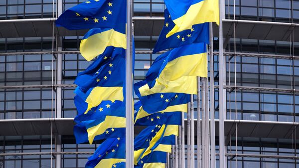 A picture taken on February 24, 2023 shows European Union's and Ukrainian flags fluttering outside the European Parliament in Strasbourg, eastern France. - Sputnik International