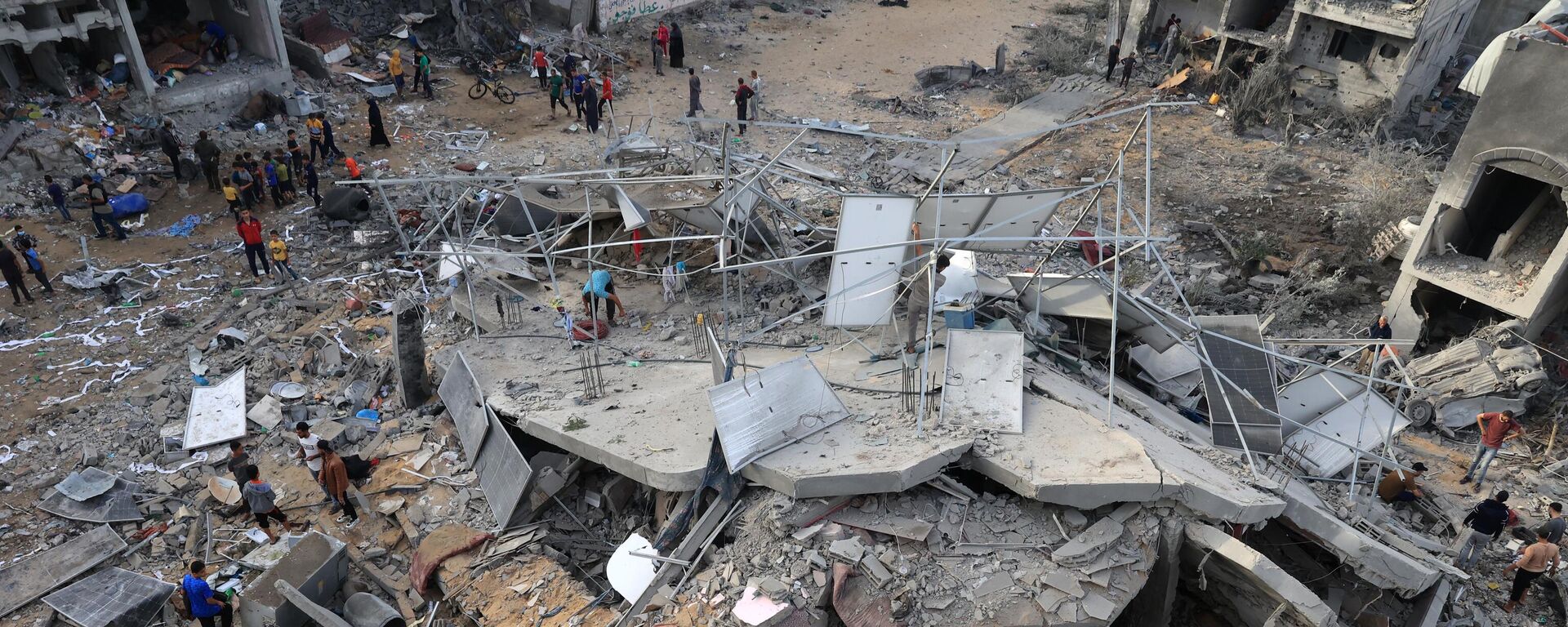 This aerial picture shows people gathered around a destroyed building following Israeli bombing on Rafah in the southern Gaza Strip, on November 11, 2023. - Sputnik International, 1920, 21.11.2023