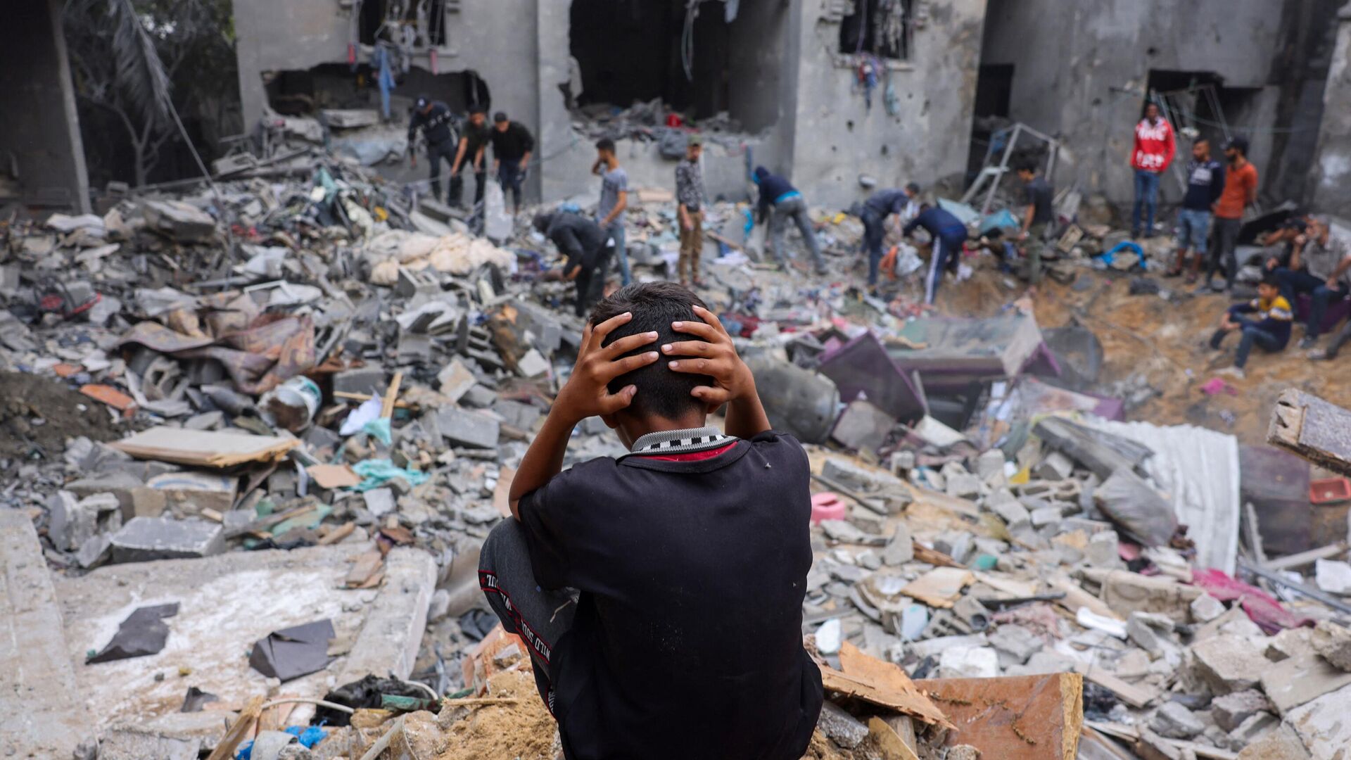 A child reacts as people salvage belongings amid the rubble of a damaged building following strikes on Rafah in the southern Gaza Strip. - Sputnik International, 1920, 15.11.2023