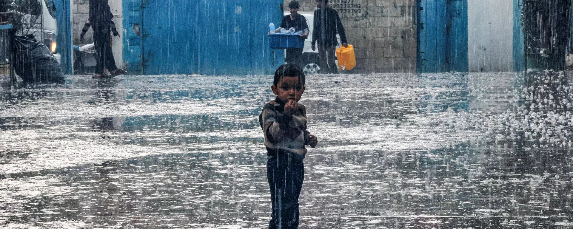 A boy stands in the rain at a school run by the United Nations Relief and Works Agency for Palestine Refugees in the Near East (UNRWA) in Rafah in the southern Gaza Strip on November 14, 2023. - Sputnik International, 1920, 14.11.2023