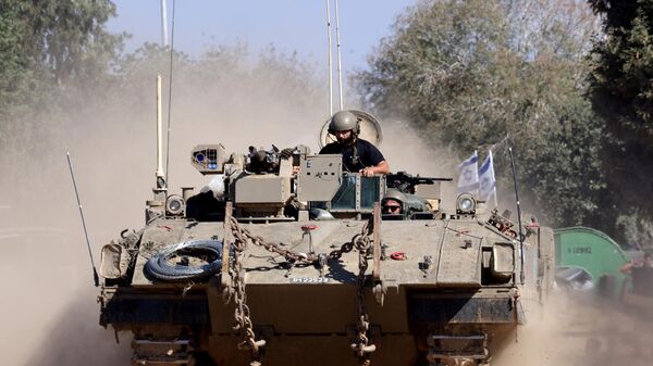 Israeli soldiers ride in an armoured vehicle as it moves into positioned close to the Israel's border with the Gaza Strip, in southern Israel on November 16, 2023. - Sputnik International