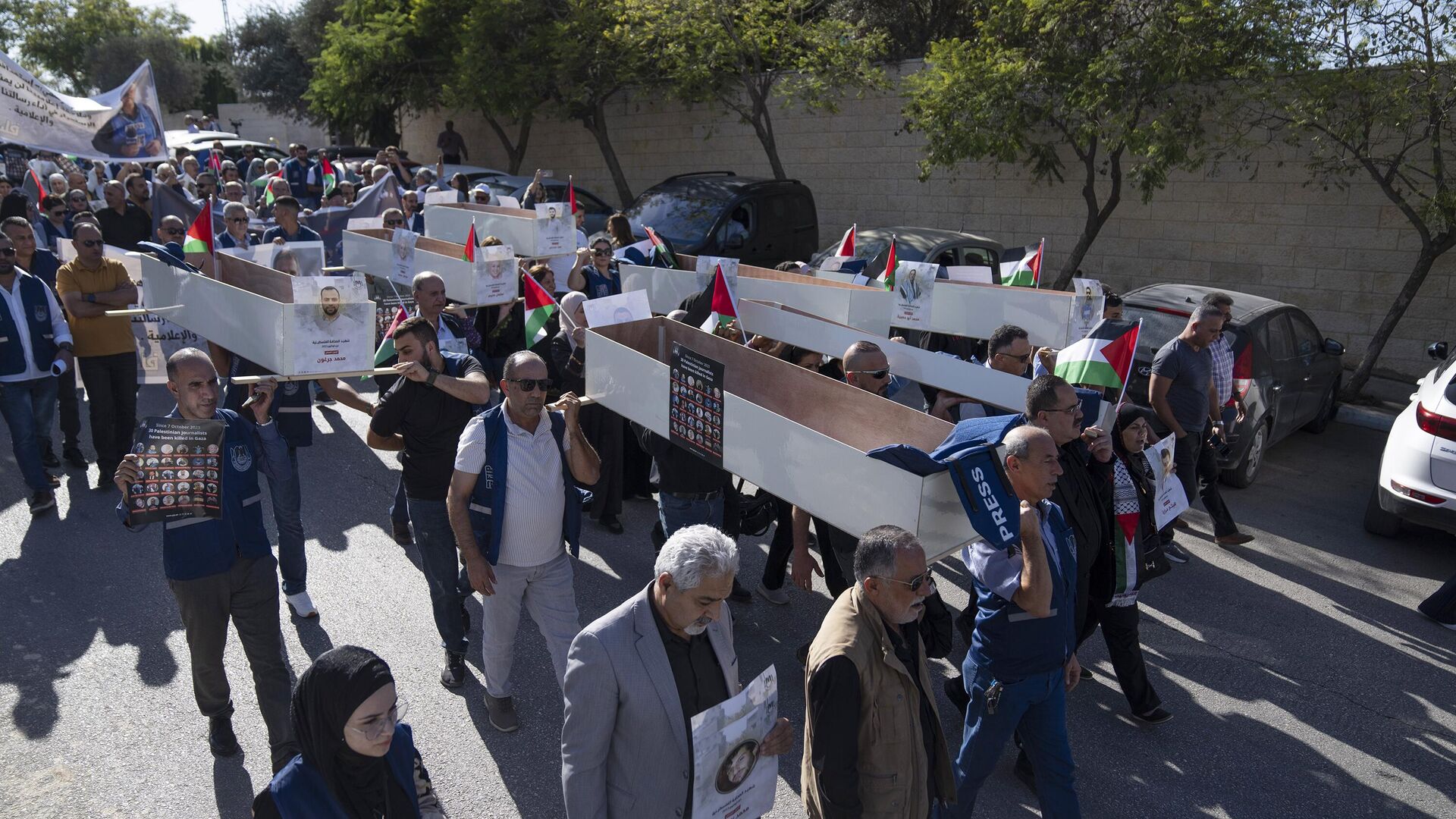Palestinian journalists carry mock coffins of Palestinian journalists who were killed during the current war in Gaza during a symbolic funeral toward a United Nations office, in the West Bank city of Ramallah - Sputnik International, 1920, 17.11.2023