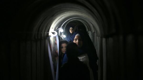 Palestinians walk inside a tunnel used for military exercises during a weapon exhibition at a Hamas-run youth summer camp, in Gaza City, on July 21, 2016. - Sputnik International