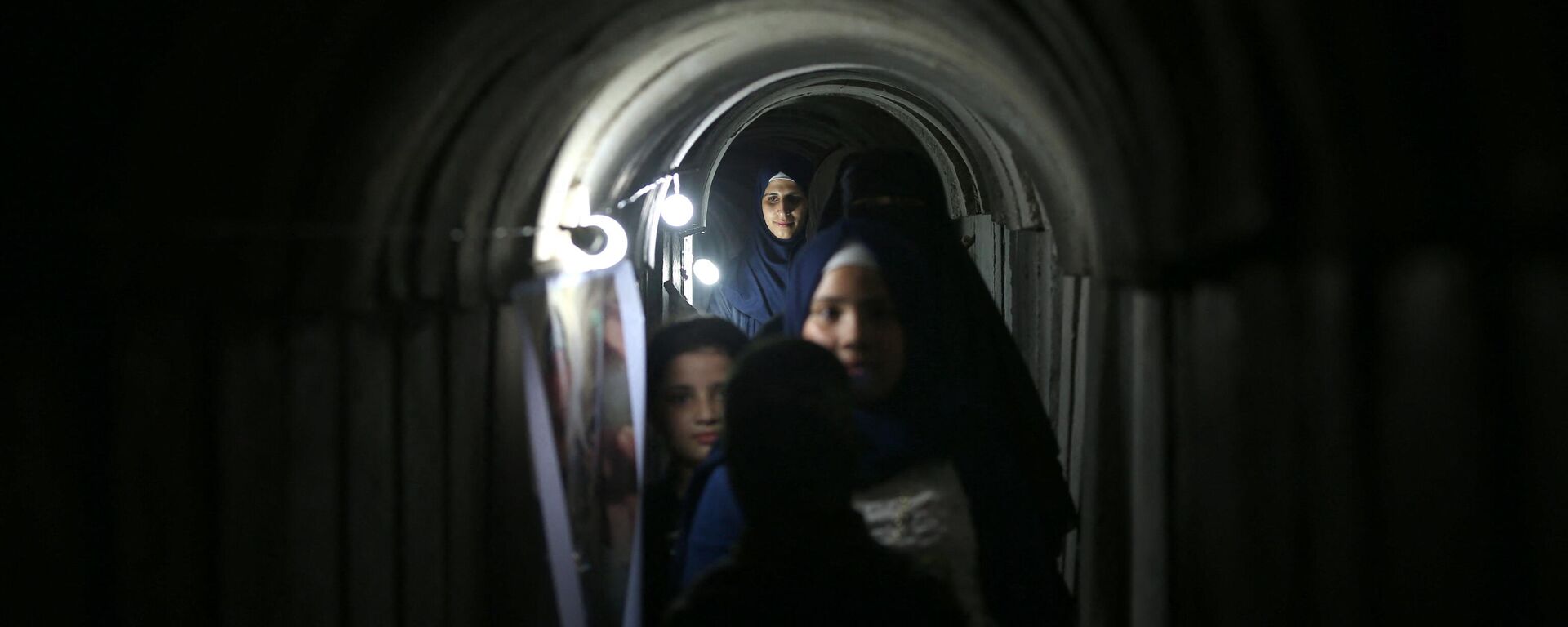 Palestinians walk inside a tunnel used for military exercises during a weapon exhibition at a Hamas-run youth summer camp, in Gaza City, on July 21, 2016. - Sputnik International, 1920, 17.11.2023