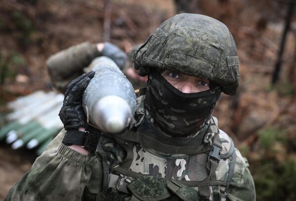 Soldiers carrying a shell for BM-21 &quot;Grad&quot; MLRS in the Krasnolimanskoye direction. - Sputnik International