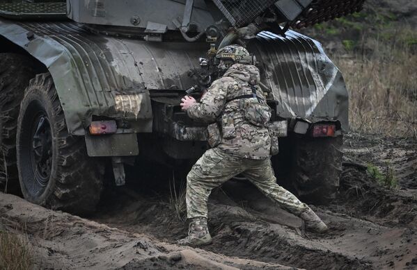 A serviceman near a BM-21 Grad MLRS during the special military operation. - Sputnik International