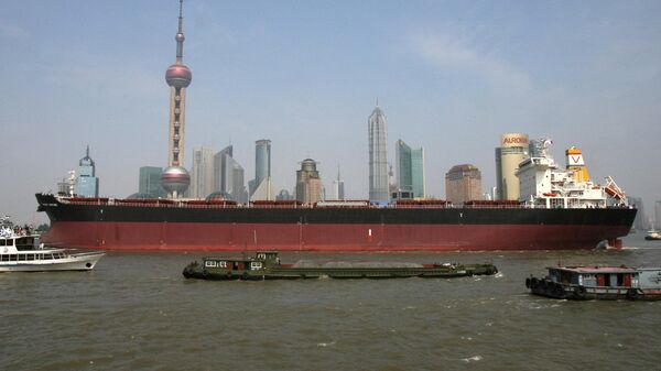 A large cargo vessel makes it's way down the Huangpu River in front of the Pudong financial district in Shanghai - Sputnik International