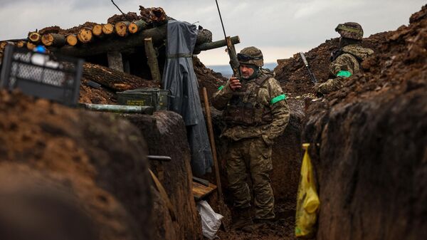 Ukrainian infantrymen of the 57th Separate Motorized Infantry Brigade Otaman Kost Khordienko stand in a trench at an undisclosed location near the town of Bakhmut, Donetsk region, eastern Ukraine on April 13, 2023, amid the Russian invasion of Ukraine. - Sputnik International
