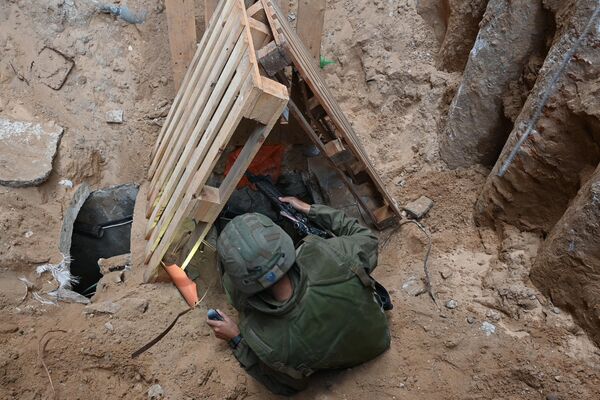A soldier climbs into what the Israeli Army says is the entrance to a tunnel dug by Hamas militants inside the Al-Shifa hospital. - Sputnik International