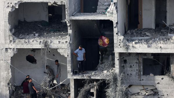 People retrieve personal effects from a bombed-out building following an Israeli strike on Rafah in the southern Gaza Strip, on November 11, 2023, as battles between Israel and the Palestinian militant group Hamas rage on.  - Sputnik International