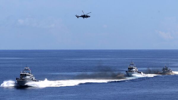Philippine navy AW159 anti-submarine helicopter (top) hovers above patrol boats during a navy's capability demonstration, witnessed by Philippine President Ferdinand Marcos Jr. (not pictured) aboard the Philippine navy ship BRP Davao del Sur, a Tarlac-class landing platform dock, off Zambales, facing the South China Sea on May 19, 2023. - Sputnik International
