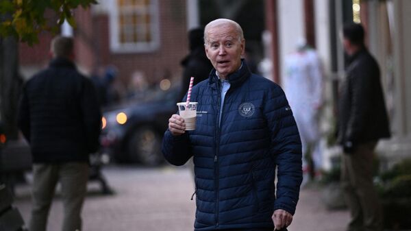 US President Joe Biden carries a beverage as he visits local shops with relatives in Nantucket, Massachusetts, on November 25, 2023.  - Sputnik International