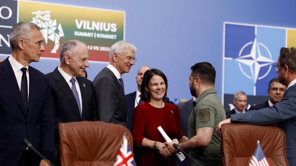 Ukraine's President Volodymyr Zelensky greeted by NATO Secretary General Jens Stoltenberg and German Foreign Minister Annalena Baerbock as he arrives to attend a meeting of the NATO-Ukraine Council during the NATO Summit in Vilnius on July 12, 2023. - Sputnik International