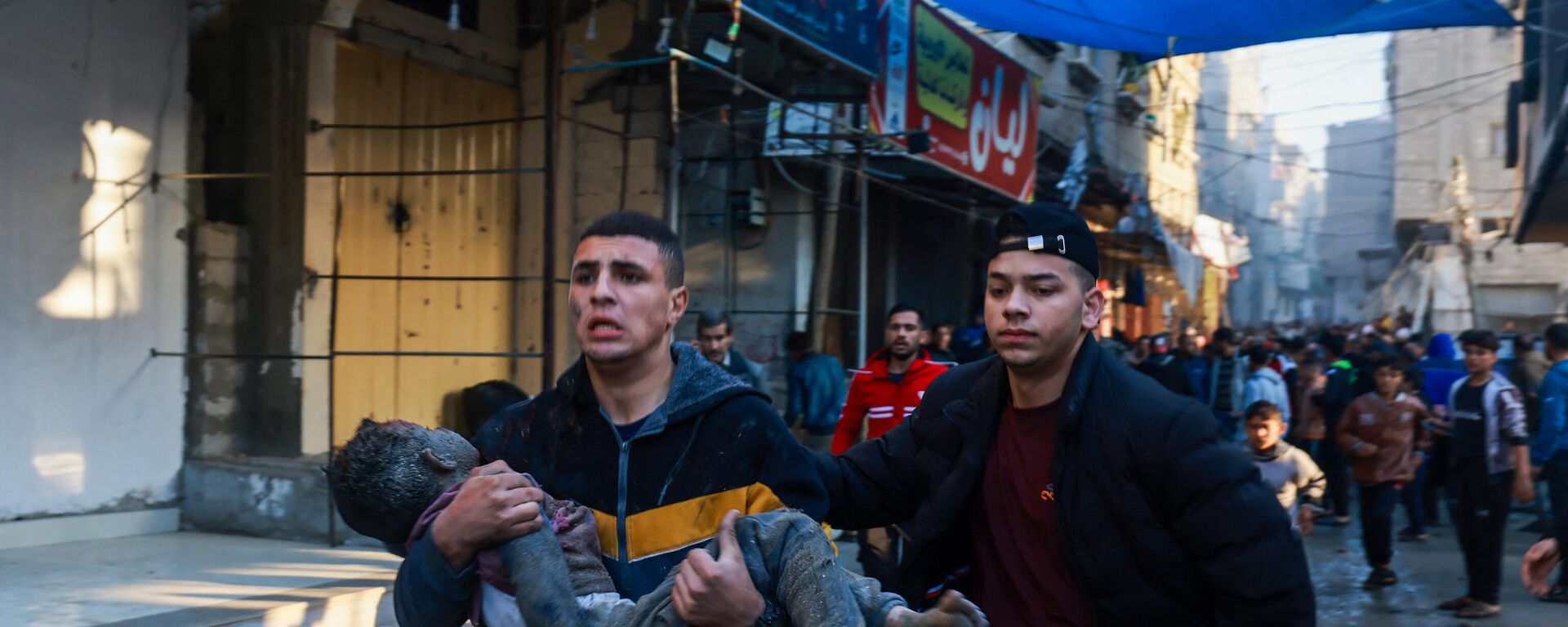 A Palestinian man carries an injured boy following the resumption of Israeli bombardment in Rafah, southern Gaza Strip, on December 1, 2023. - Sputnik International, 1920, 01.12.2023