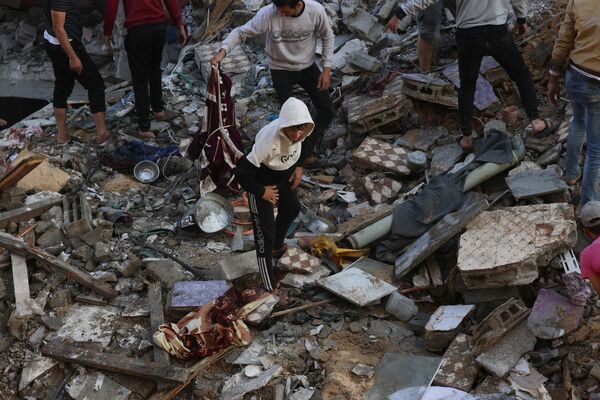 Palestinians inspect the destruction following an Israeli strike in Rafah in the southern Gaza Strip on December 1, 2023, as fighting resumed shortly after the expiration of a seven-day pause. - Sputnik International