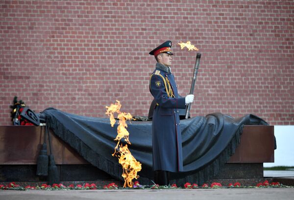 A serviceman of the Honor Guard holds a torch with the Eternal Flame near the Tomb of the Unknown Soldier. - Sputnik International