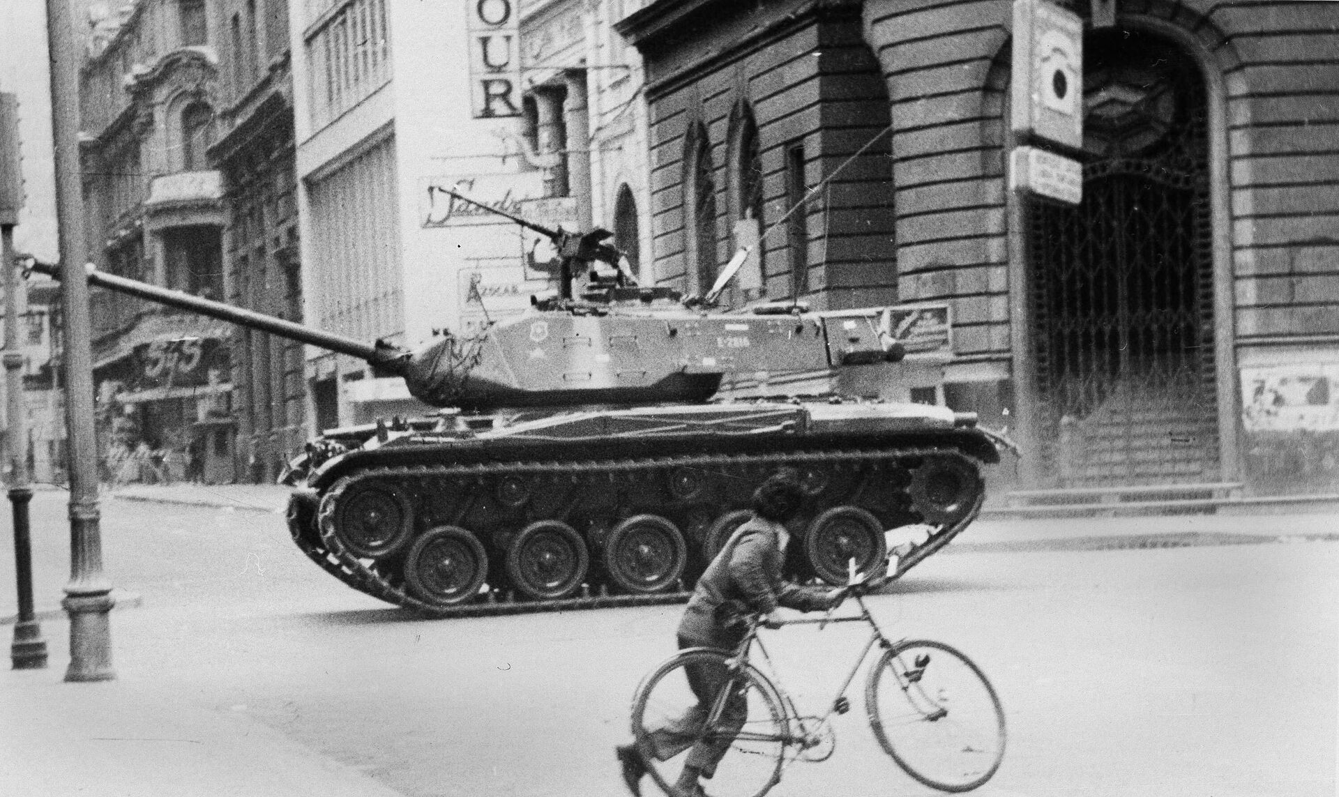 FILE - In this Sept. 11, 1973 file photo, a boy pushes a bicycle across a deserted street as an army tank moves towards La Moneda presidential palace during a coup against President Salvador Allende's government, after which Gen. Augusto Pinochet seized power, in Santiago, Chile. Chile marks the 45th anniversary of the coup led by Pinochet overthrowing Allende, on Wednesday, Sept. 11, 2018. - Sputnik International, 1920, 03.12.2023