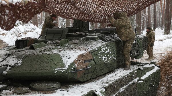 Ukrainian tank crew members of the 21st Mechanized Brigade stands on a snow covered German made Leopard 2A5 battle tank near the front line in an undisclosed location in the Lyman direction of the Donetsk region, on November 21, 2023 - Sputnik International