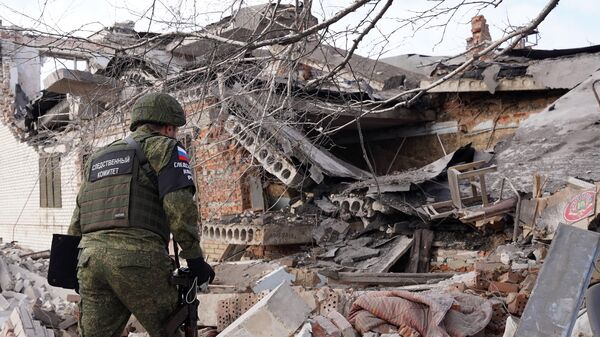 A Russian Investigative Committee officer explores a building destroyed after a recent shelling, as Russia's military operation in Ukraine continues, in Volnovakha, Donetsk People's Republic, Russia - Sputnik International