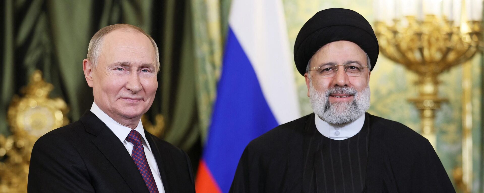 Russia's President Vladimir Putin (L) shakes hands with Iran's President Ebrahim Raisi during their meeting in the Kremlin in Moscow on December 7, 2023 - Sputnik International, 1920, 25.12.2023
