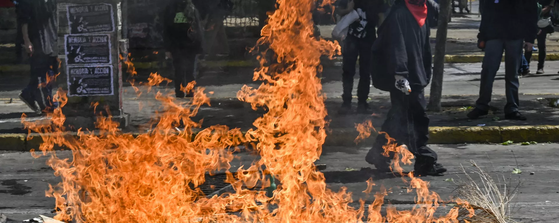 Demonstrators block a street with a barricade set on fire during a protest to commemorate the third anniversary of a social uprising against rising utility prices, in the surroundings of the Baquedano square in Santiago, on October 18, 2022 - Sputnik International, 1920, 08.12.2023