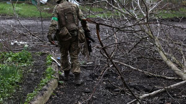 A Ukrainian soldier walks at a front line position on April 22, 2023. - Sputnik International