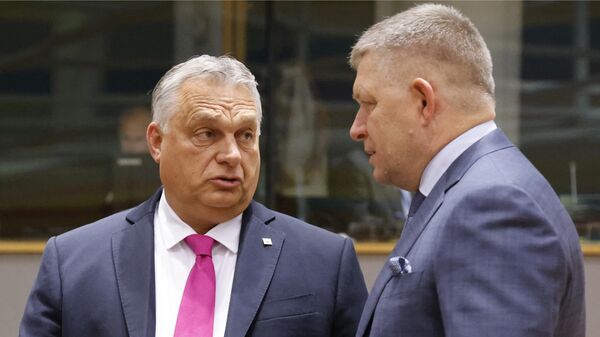 Hungary's Prime Minister Viktor Orban (L) speaks with Slovakia's Prime Minister Robert Fico prior to the start of a EU leaders Summit at The European Council Building in Brussels on October 26, 2023.  - Sputnik International