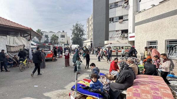 Displaced Palestinians gather in the yard of Gaza's Al-Shifa hospital on December 10, 2023. - Sputnik International