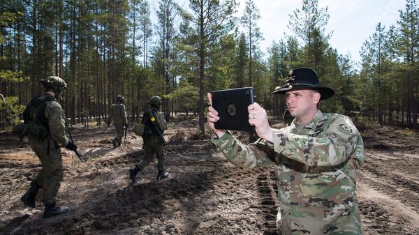 US Army Cavalry Major Neil Penttila films the action of Finnish troops with a tablet during Arrow 16 mechanised exercise of the Finnish Army in collaboration with US Army Europe's 2nd Cavalry Regiment's Mechanized Infantry Company in Niinisalo, on May 4, 2016.  - Sputnik International