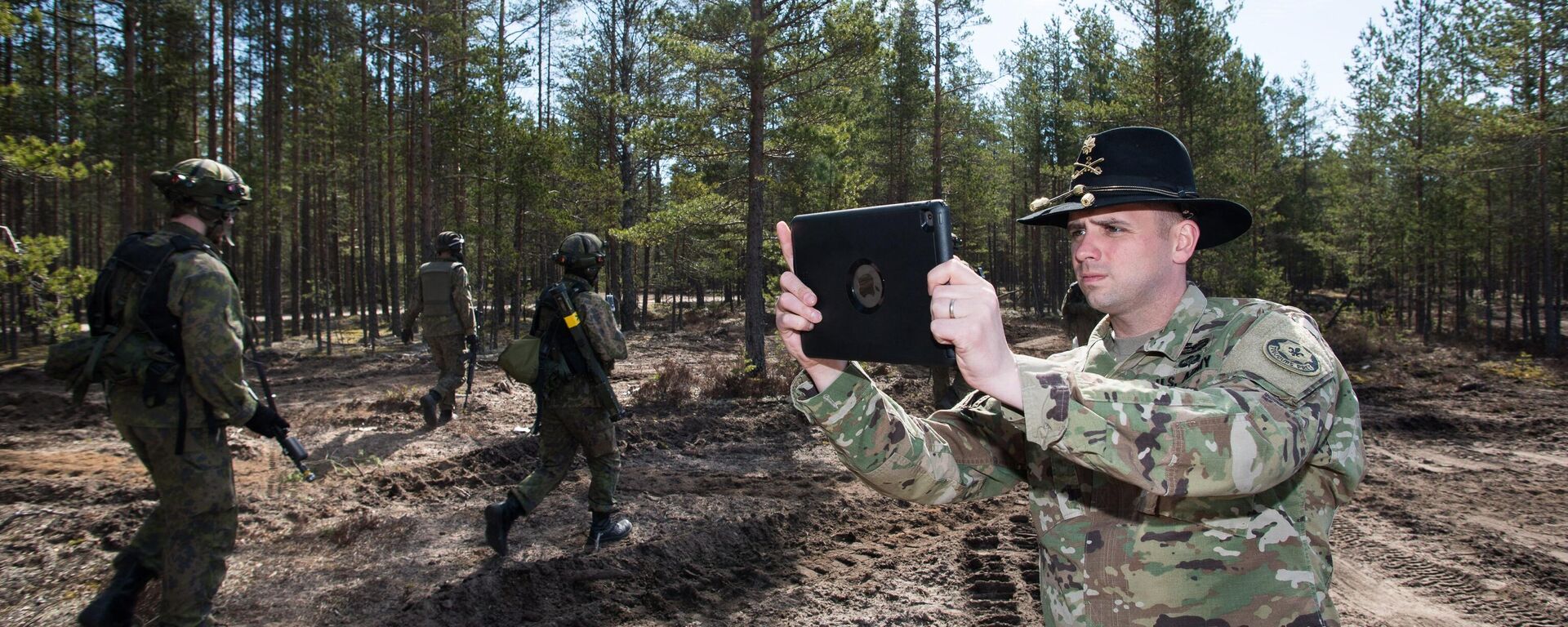 US Army Cavalry Major Neil Penttila films the action of Finnish troops with a tablet during Arrow 16 mechanised exercise of the Finnish Army in collaboration with US Army Europe's 2nd Cavalry Regiment's Mechanized Infantry Company in Niinisalo, on May 4, 2016.  - Sputnik International, 1920, 15.12.2023