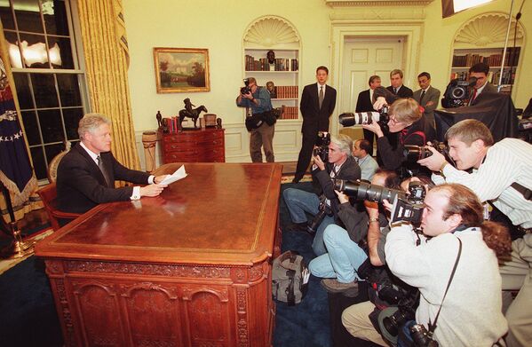 Photographers take pictures of US President Bill Clinton as he prepares to address the nation on December 16 from the White House in Washington, DC. Clinton&#x27;s remarks came shortly after Baghdad was rocked by a series of violent explosions and anti-aircraft gunfire that lit up the night sky over the Iraqi capital. - Sputnik International