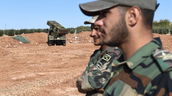 Syrian Army soldiers stand close to a rocket-artillery vehicle in the country's north. File photo. - Sputnik International