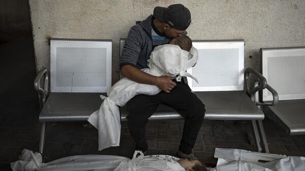 Palestinians mourn their relatives killed in the Israeli bombardment of the Gaza Strip, at the hospital Rafah, Gaza. - Sputnik International