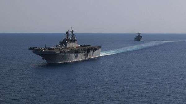 In this photo released by the U.S. Navy, the amphibious assault ship USS Bataan, front, and the landing ship USS Carter Hall, back travel through the Red Sea - Sputnik International