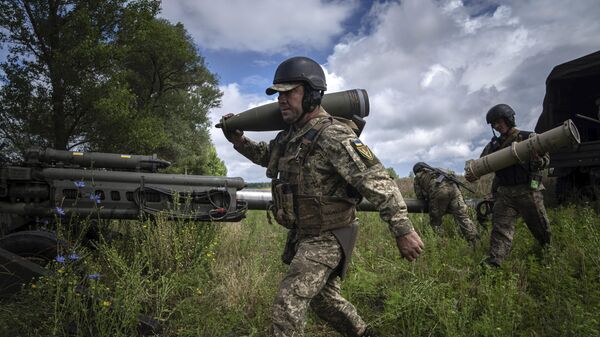 Украинский военный со снарядом 155 мм в Харьковской области. Архивное фото  - Sputnik International