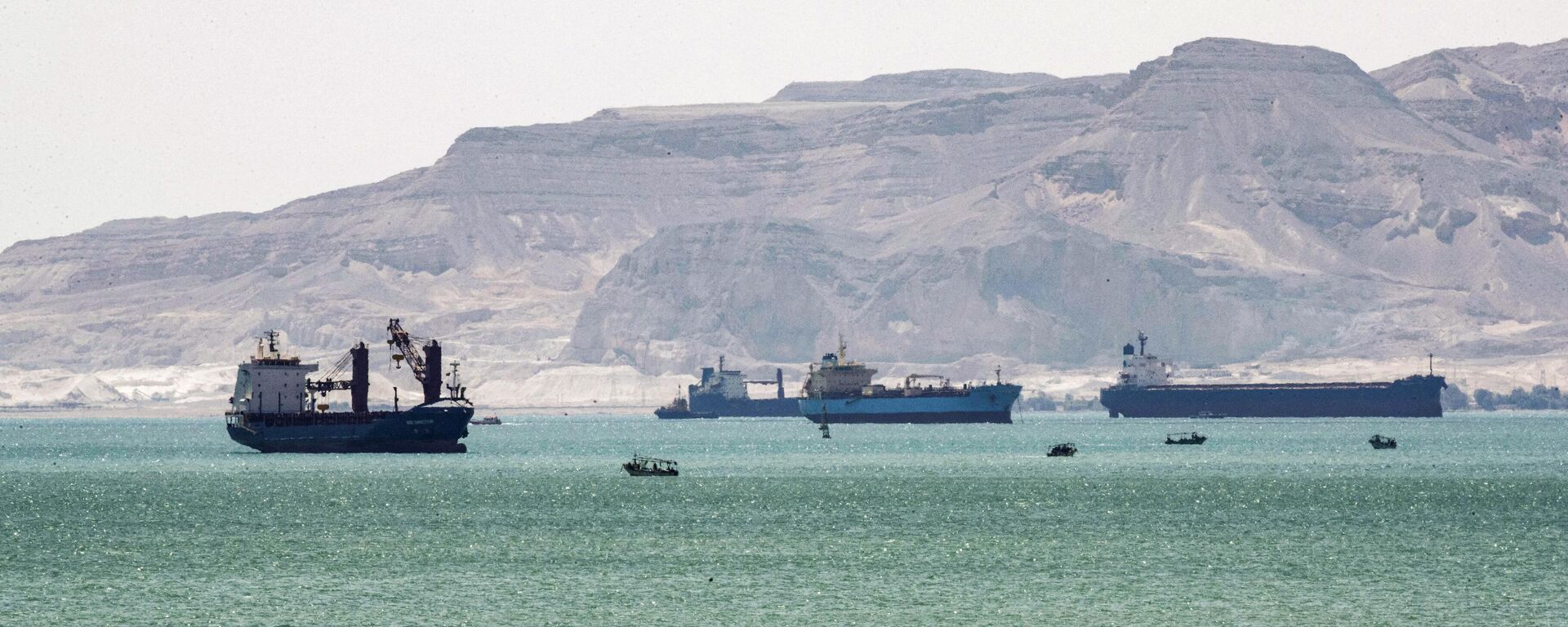 This picture taken on March 28, 2021 shows tanker and freight ships near the entrance of the Suez Canal, by Egypt's Red Sea port city of Suez. - Sputnik International, 1920, 24.12.2023