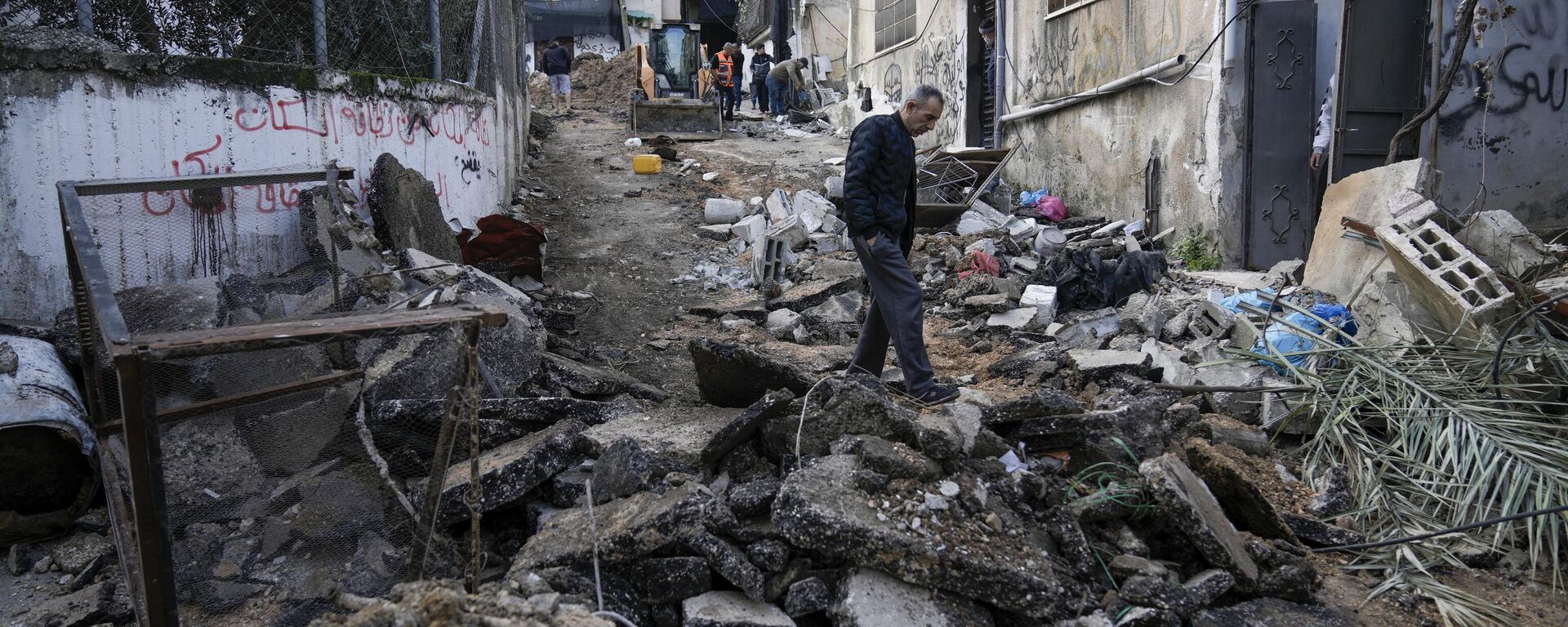 Palestinians walk through the aftermath of the Israeli military raid on Nur Shams refugee camp in the West Bank, Wednesday, Dec. 27, 2023. Israel's forces raided a refugee camp in the northern occupied West Bank, killing at least six Palestinians, Palestinian health authorities said early Wednesday. - Sputnik International, 1920, 28.12.2023