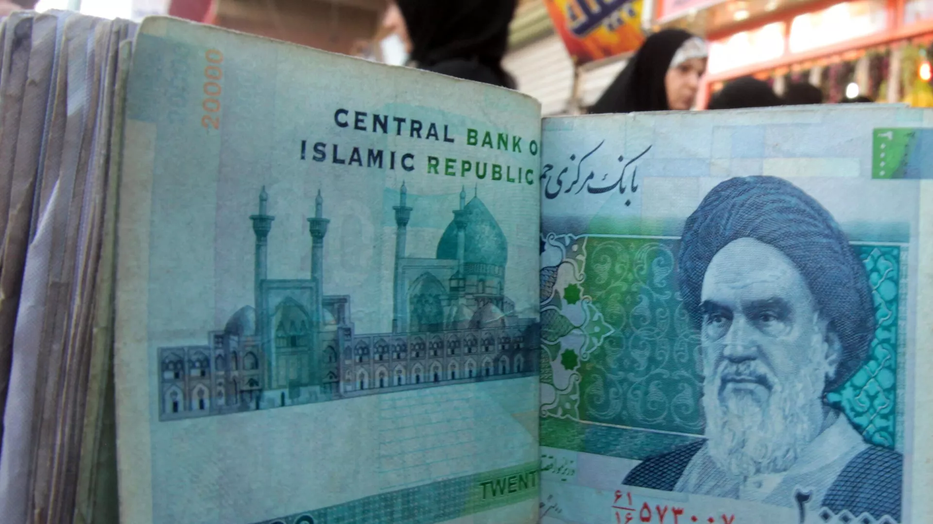 An Iraqi money dealer counts Iranian rial banknotes bearing a portrait of the late founder of the Islamic Republic of Iran, Ayatollah Ruhollah Khomeini, at an exchange office in Baghdad on February 3, 2012 - Sputnik International, 1920, 28.12.2023