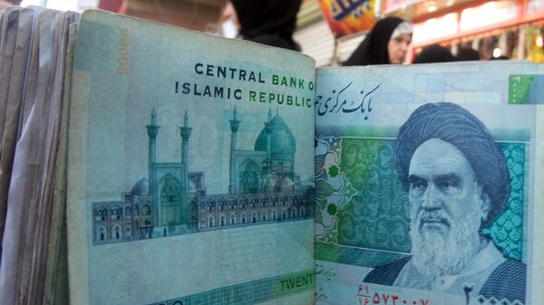 An Iraqi money dealer counts Iranian rial banknotes bearing a portrait of the late founder of the Islamic Republic of Iran, Ayatollah Ruhollah Khomeini, at an exchange office in Baghdad on February 3, 2012 - Sputnik International