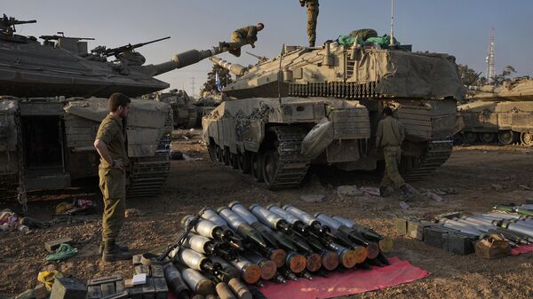 Israeli soldiers load shells onto a tank at a staging area in southern Israel near the border with Gaza on Sunday, Dec. 31, 2023. - Sputnik International