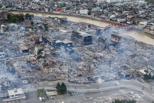 This aerial photo shows smoke rising from an area following a large fire in Wajima a day after a major 7.5-magnitude earthquake struck the Noto region. - Sputnik International