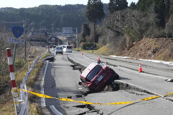 A car is trapped on a partially collapsed road due to a powerful earthquake near the town of Anamizu, Ishikawa Prefecture. - Sputnik International
