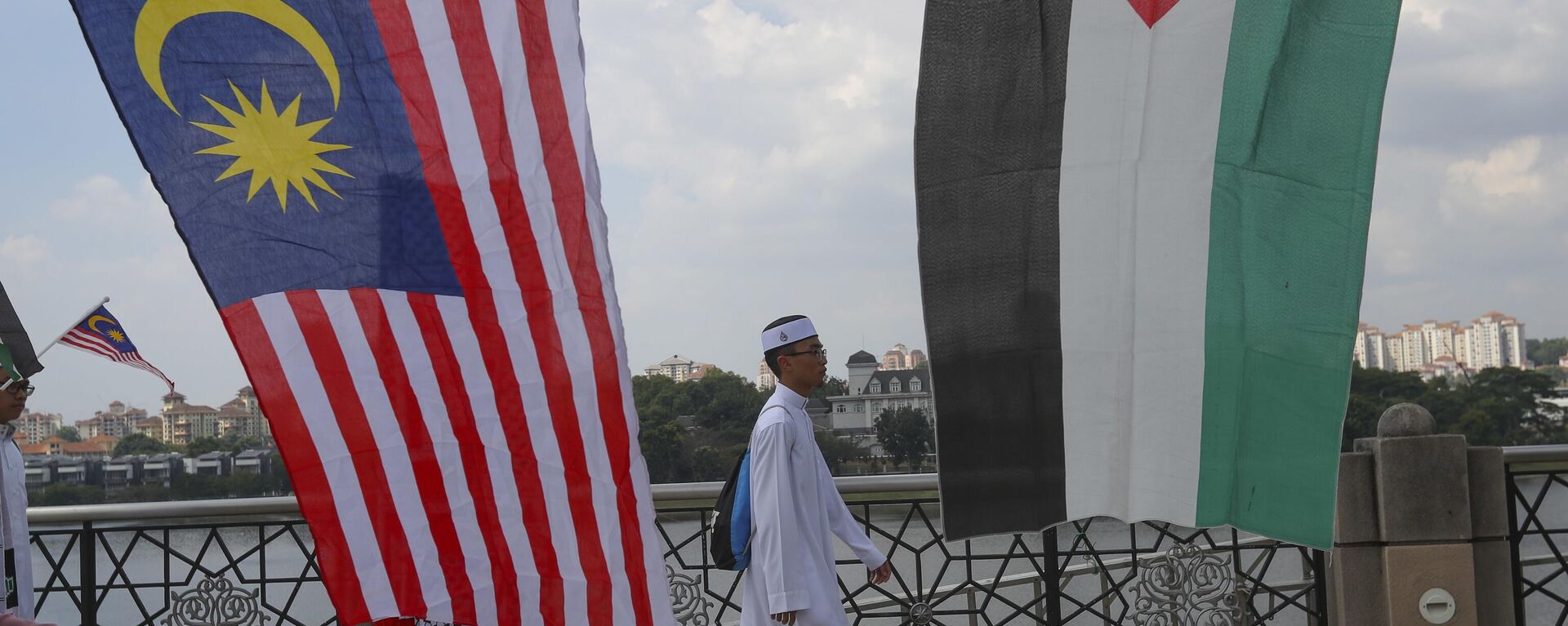 A Muslim walks to Friday prayer as Malaysia and Palestine flags on display in Putrajaya, Malaysia, Friday, Dec. 22, 2017. Malaysia Prime Minister Najib Razak leads huge rally to protest US move to recognize Jerusalem as Israel's capital. (AP Photo/Vincent Thian) - Sputnik International, 1920, 03.01.2024