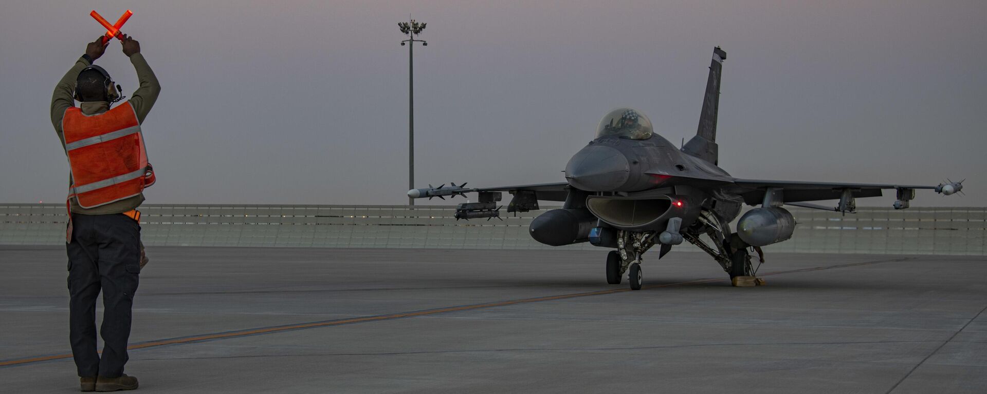 In this handout photo from the U.S. Air Force, an airman guides an F-16 Fighting Falcon during training at Al-Udeid Air Base, Qatar, Jan. 24, 2022.  - Sputnik International, 1920, 16.01.2024