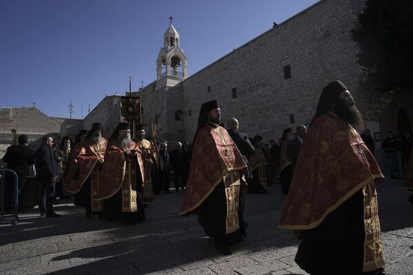 Orthodox priests walk outside the Nativity Church, where Christians believe Jesus Christ was born on the eve of the Orthodox Christmas in Bethlehem, West Bank. - Sputnik International
